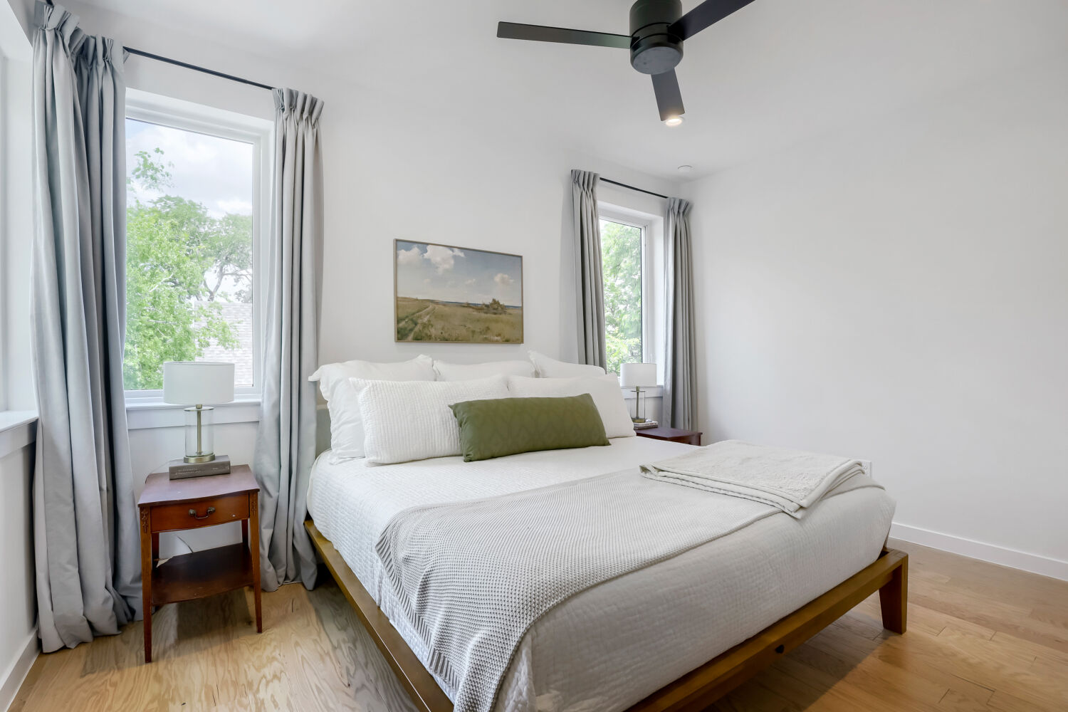 4804 Ribbecke Avenue, Unit A Austin, TX 78721 - Photo 15 of 32 This room features hardwood flooring, white walls, and a black ceiling fan with an integrated light