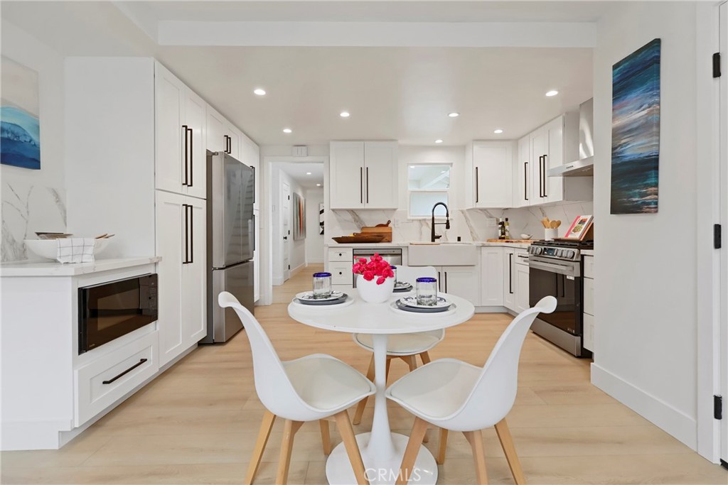 2316 La Linda Place Newport Beach, CA 92660 - Photo 29 of 31 a kitchen with stainless steel appliances kitchen island granite countertop a kitchen island and chairs