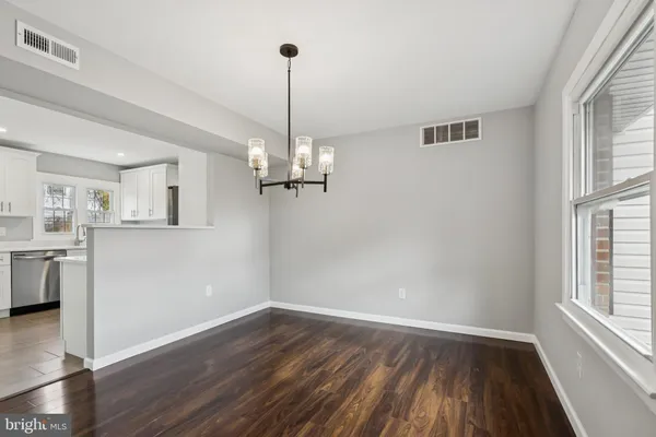 a view of empty room with wooden floor and window