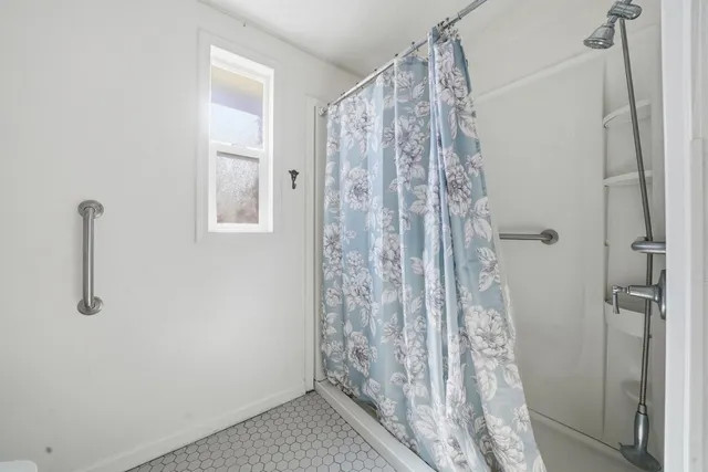 a bathroom with a shower curtain and a window