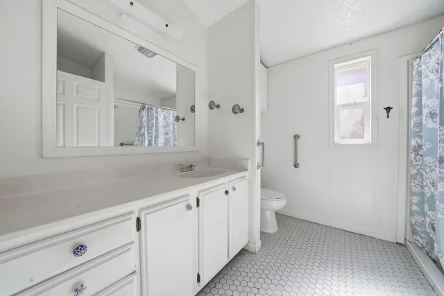 a bathroom with a granite countertop sink a toilet and a mirror