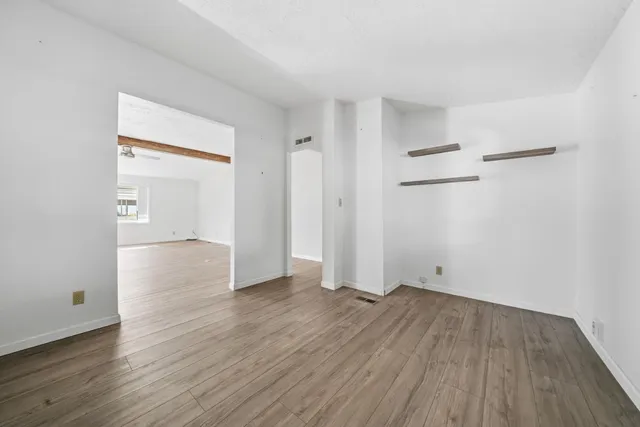 a view of an empty room with wooden floor