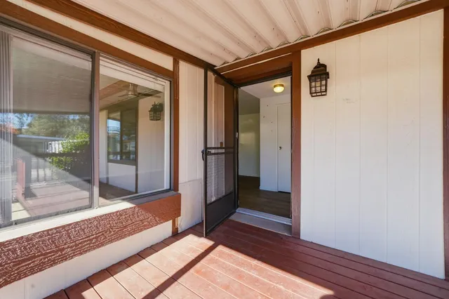 a view of a hallway with wooden floor and a glass door