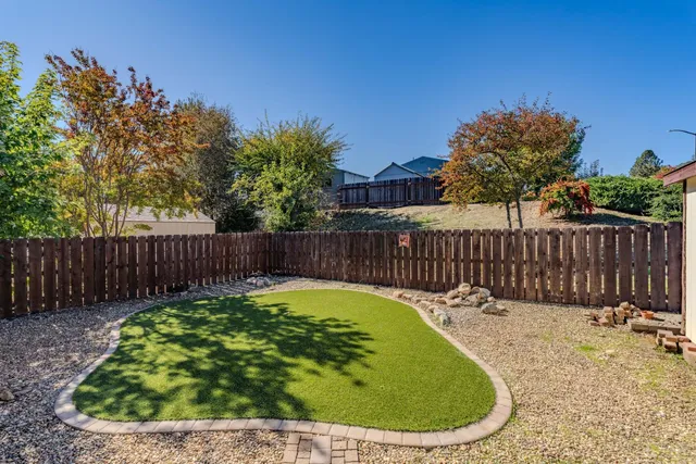 a view of a backyard with a small swimming pool and wooden fence