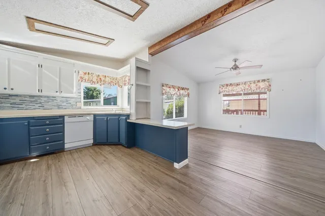 a kitchen with stainless steel appliances kitchen island wooden cabinets a window and a sink