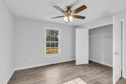 an empty room with window and ceiling fan