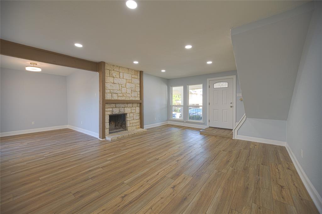 733 Intrepid Drive Garland, TX 75043 - Photo 7 of 25 living room with recessed lighting, light wood-style flooring, and a stone fireplace