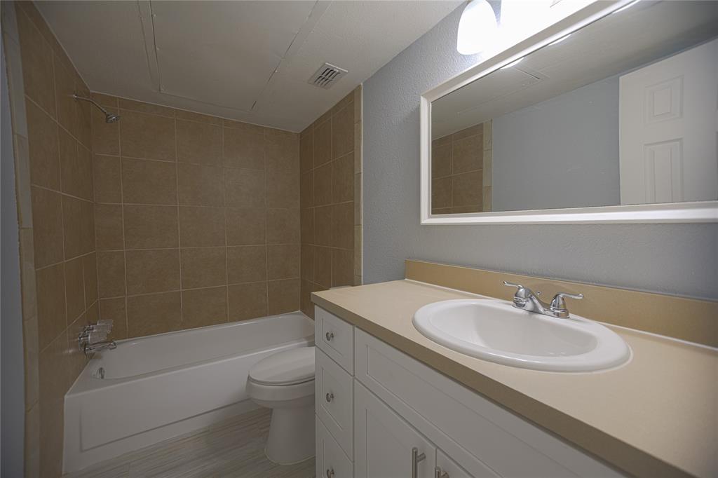 733 Intrepid Drive Garland, TX 75043 - Photo 10 of 25 Full downstairs bathroom featuring shower / tub combination, vanity, and a textured wall