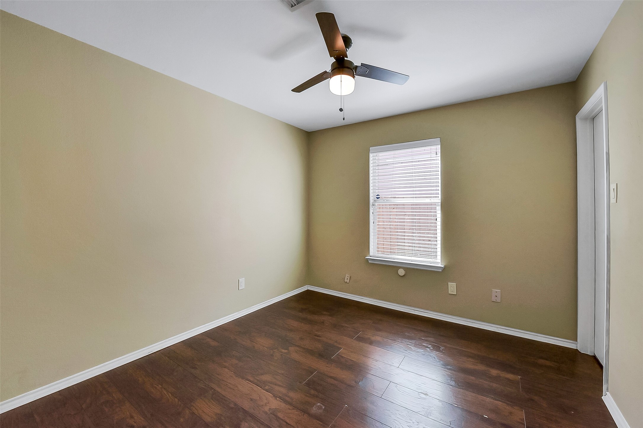 20011 Spring Wreath Lane Cypress, TX 77433 - Photo 13 of 39 Secondary bedroom #1 located downstairs, showcasing wood flooring and a neutral palette.