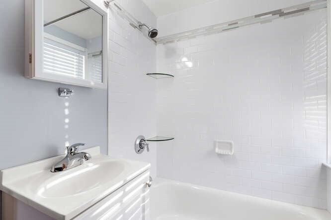 13 Highland Street Wakefield, MA 01880 - Photo 11 of 35 a bathroom with a sink a mirror and a shower