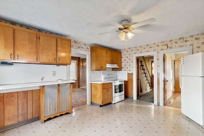 13 Highland Street Wakefield, MA 01880 - Photo 5 of 35 a kitchen with a stove a refrigerator and cabinets