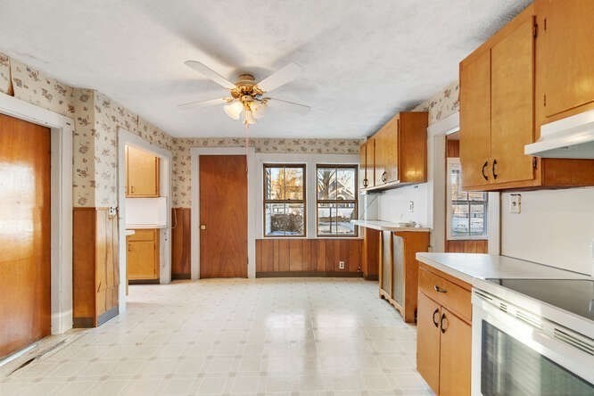 13 Highland Street Wakefield, MA 01880 - Photo 6 of 35 a view of a kitchen with a stove top oven a sink dishwasher and wooden cabinets