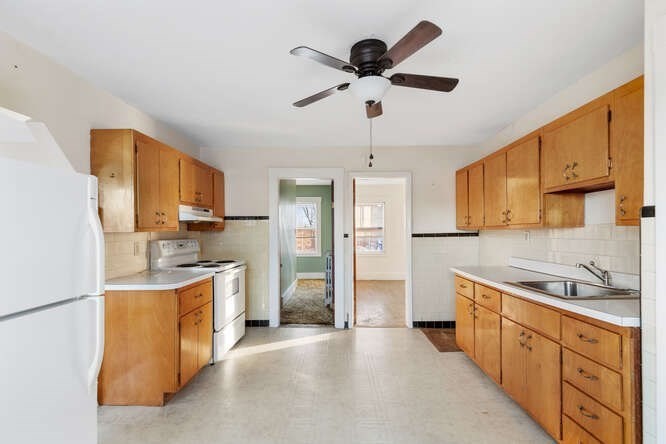13 Highland Street Wakefield, MA 01880 - Photo 7 of 35 a kitchen with stainless steel appliances granite countertop a sink stove oven a refrigerator with white cabinets and wooden floor