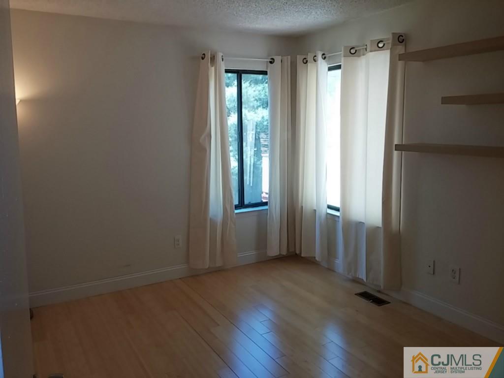 75 Park Gate Drive Edison, NJ 08820 - Photo 14 of 19 a view of an empty room with wooden floor and a window