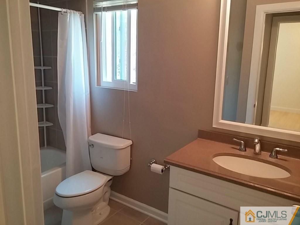 75 Park Gate Drive Edison, NJ 08820 - Photo 15 of 19 a bathroom with a granite countertop toilet a sink and a mirror