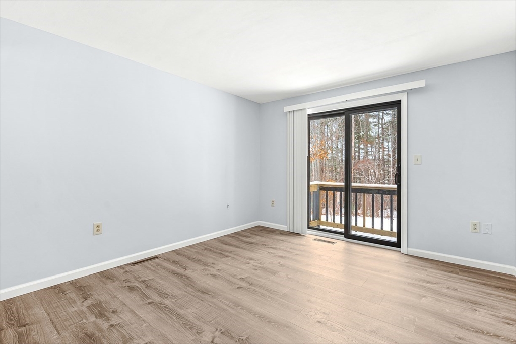 14 Centercrest Drive, Unit 14 Tyngsborough, MA 01879 - Photo 14 of 27 an empty room with wooden floor and windows