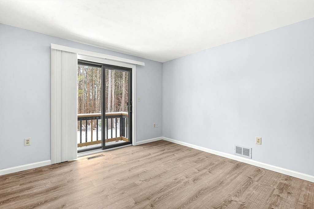 14 Centercrest Drive, Unit 14 Tyngsborough, MA 01879 - Photo 15 of 27 an empty room with wooden floor and windows