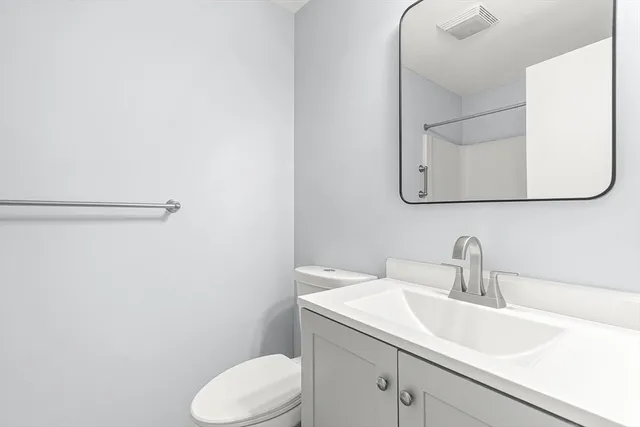 a bathroom with a sink mirror vanity and toilet