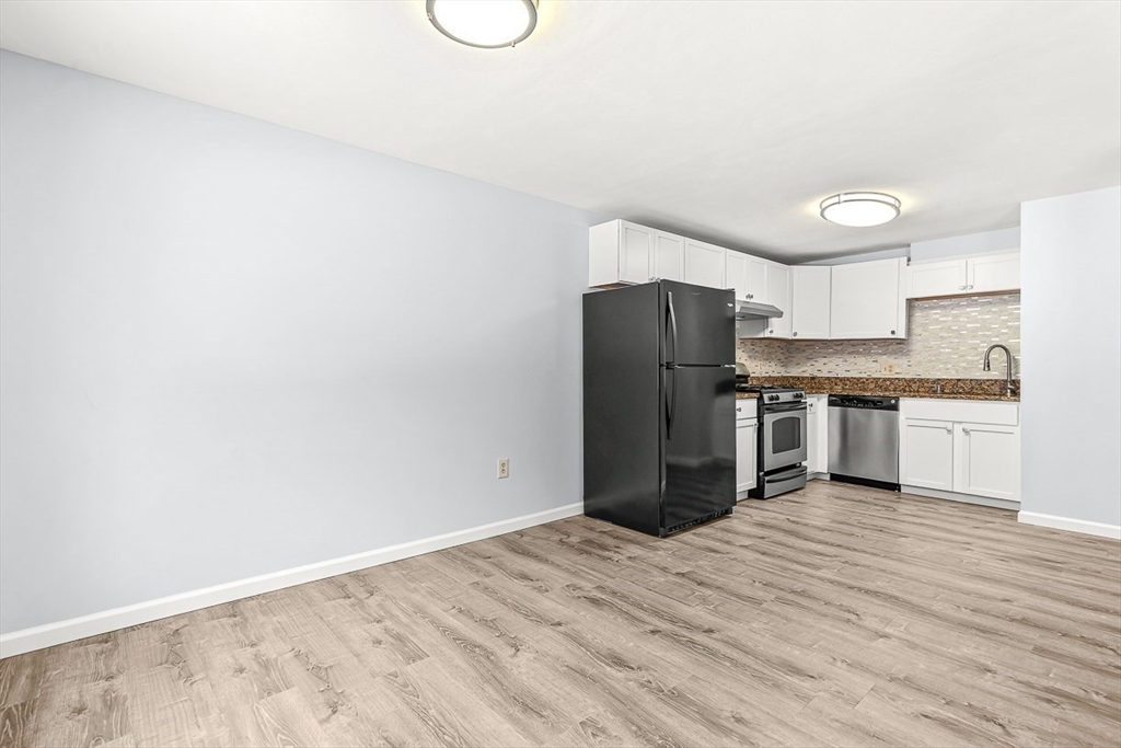 14 Centercrest Drive, Unit 14 Tyngsborough, MA 01879 - Photo 7 of 27 a kitchen with granite countertop a refrigerator and a stove top oven