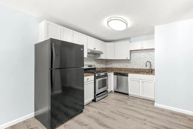 a kitchen with a refrigerator stove and wooden cabinets