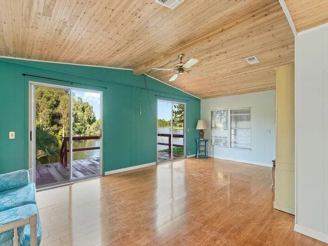 a view of an empty room with window and stairs