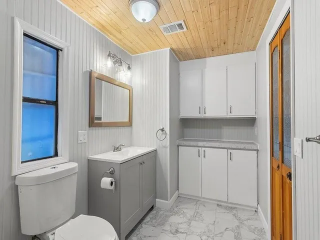 a bathroom with a toilet sink and mirror