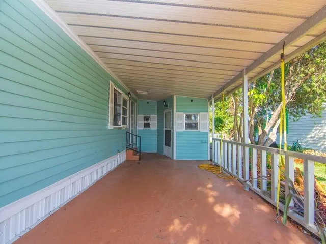 a view of a backyard with large trees and wooden fence