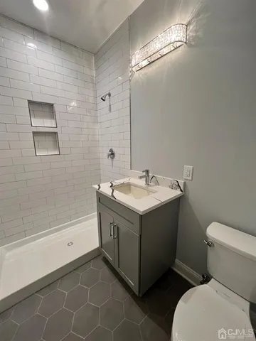 a bathroom with a sink mirror vanity and toilet