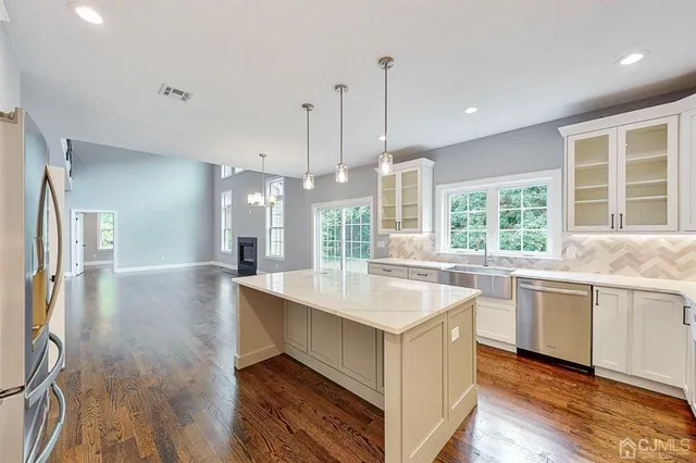 a large kitchen with kitchen island a stove a sink a center island and wooden floor