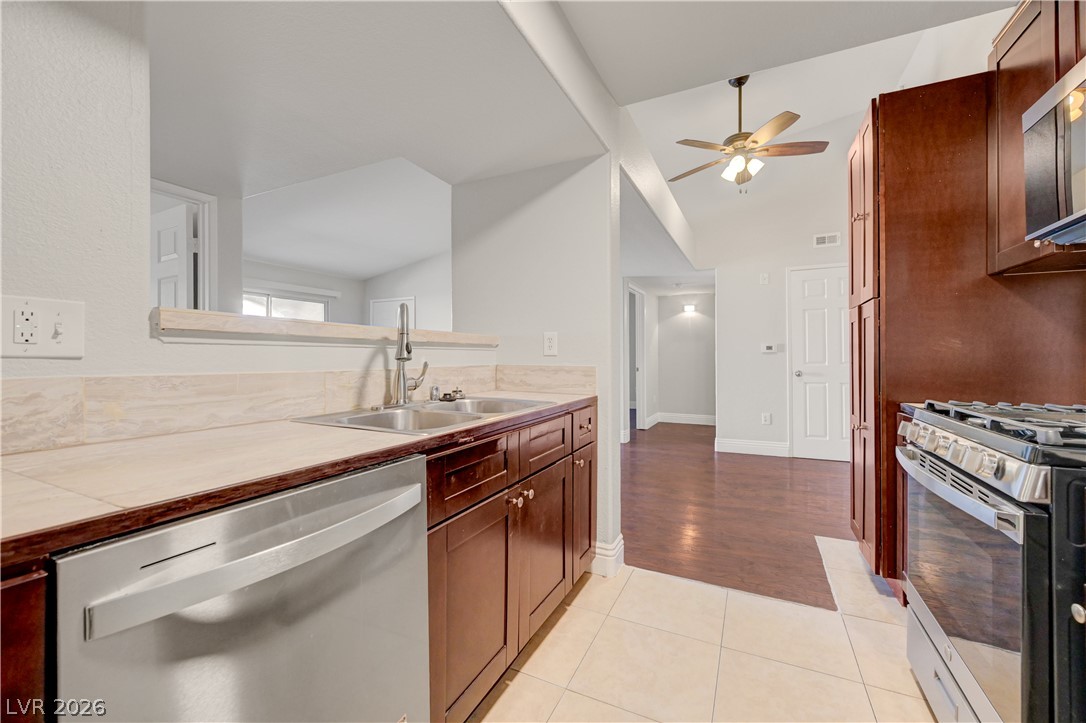 7885 West Flamingo Road, Unit 1050 Las Vegas, NV 89147 - Photo 17 of 62 An inviting kitchen space features rich wood cabinetry, stainless steel appliances, and a convenient pass-through window.