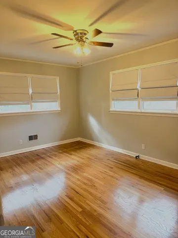 a view of a room with wooden floor and white walls