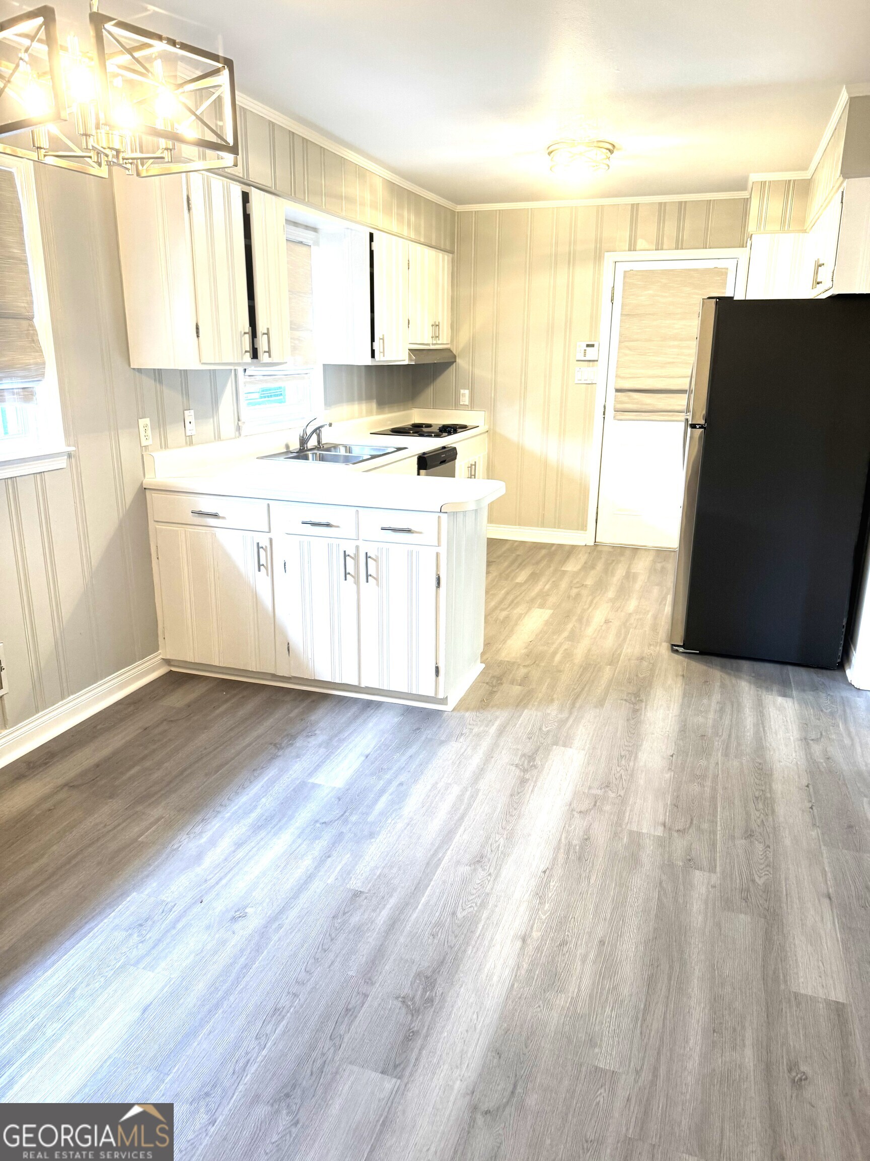 819 Ellenwood Circle Macon, GA 31204 - Photo 3 of 17 a large white kitchen with a sink wooden floor and a large window