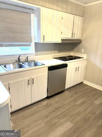 a kitchen with granite countertop white cabinets and a sink