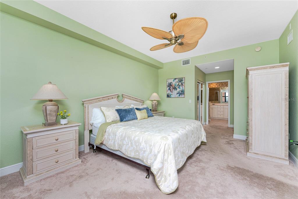 24351 Baltic Avenue, Unit 203 Punta Gorda, FL 33955 - Photo 30 of 51 a bedroom with a bed and a chandelier