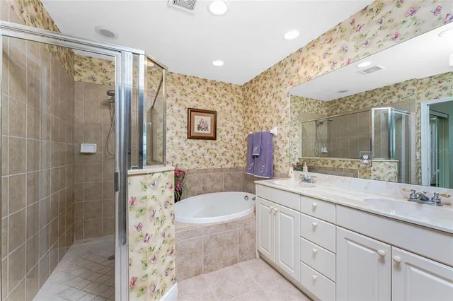 a bathroom with a granite countertop sink a mirror a bathtub and shower