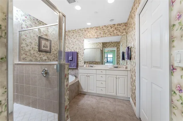 a spacious bathroom with a shower a sink and a mirror