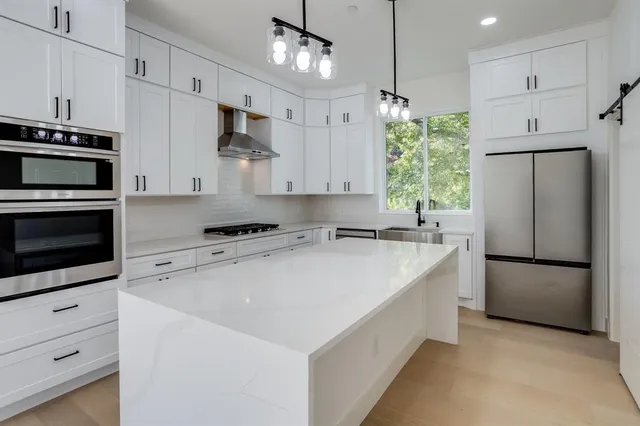 a kitchen with stainless steel appliances a refrigerator sink and microwave