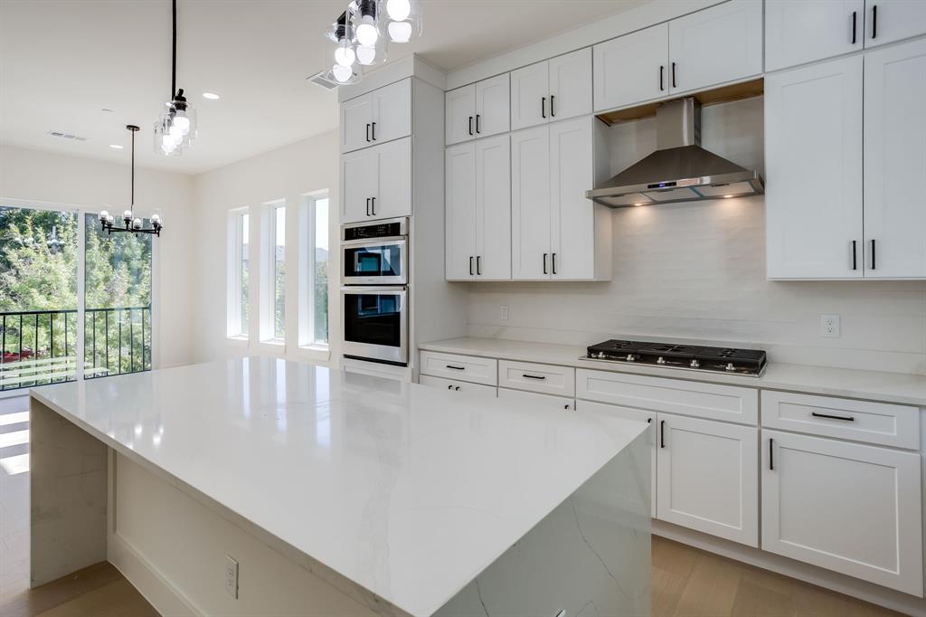 6001 Lewis Street Dallas, TX 75206 - Photo 10 of 19 a kitchen with stainless steel appliances granite countertop a sink a stove and a refrigerator