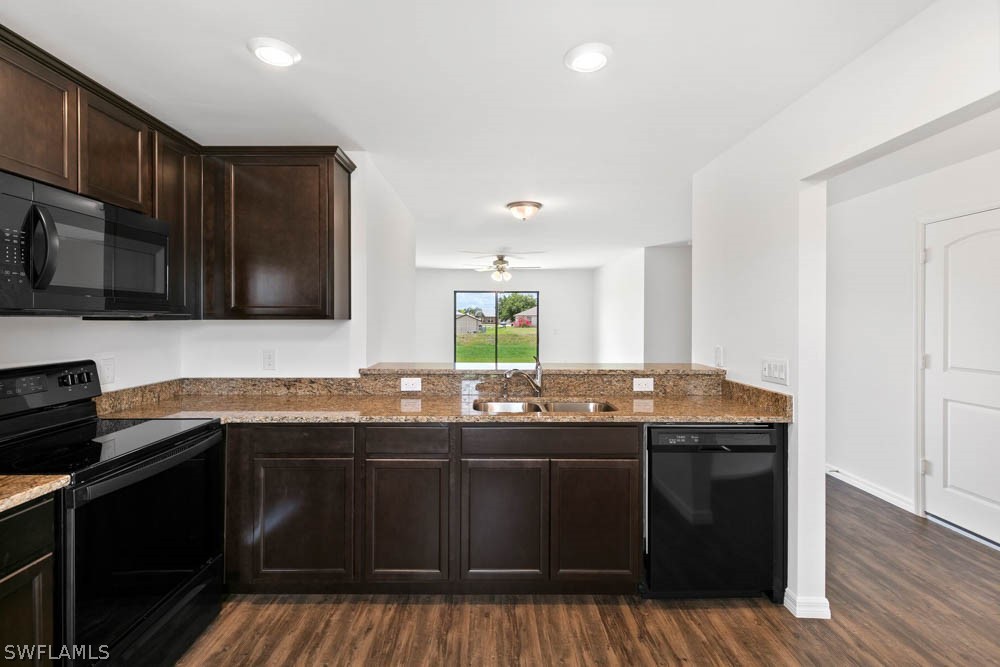 840 Rue Labeau Circle Fort Myers, FL 33913 - Photo 3 of 5 a kitchen with granite countertop wood cabinets and stainless steel appliances