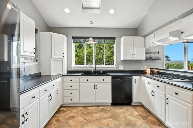 a kitchen with stainless steel appliances granite countertop a stove a sink and a refrigerator