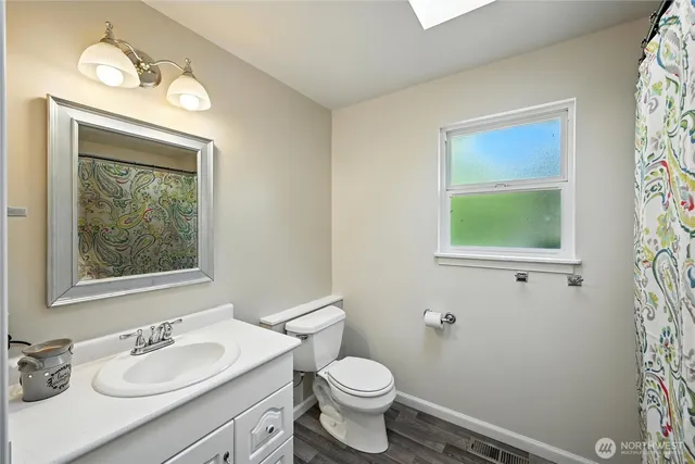 an empty room with wooden floor and a ceiling fan