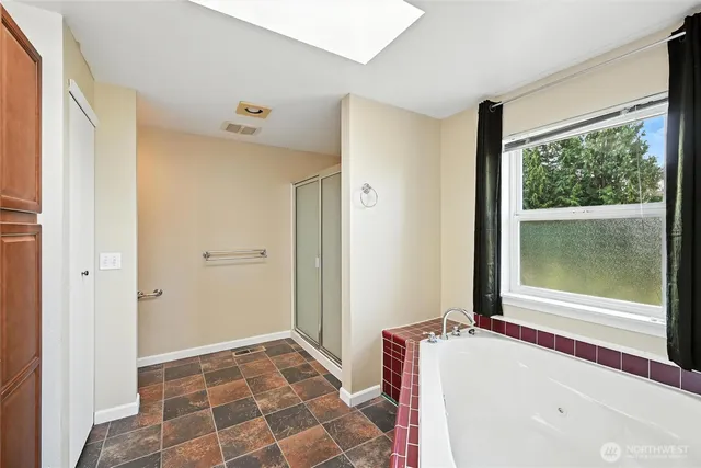 a bathroom with a tub sink and mirror