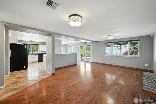 an empty room with wooden floor and windows