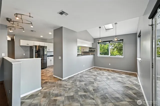 a large kitchen with cabinets a sink a window and stainless steel appliances