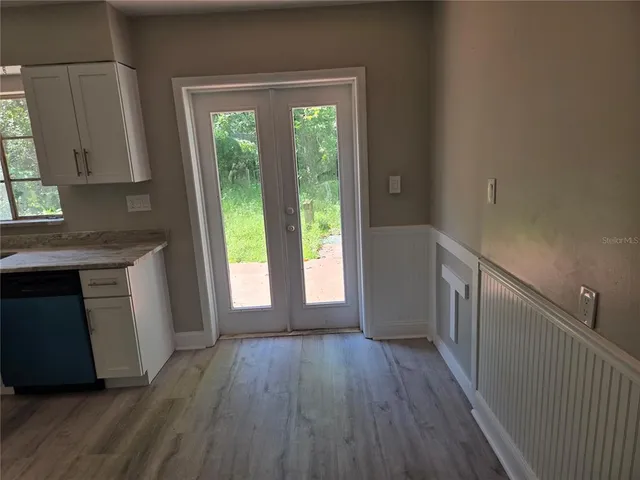 a kitchen with wooden floors and a white rack