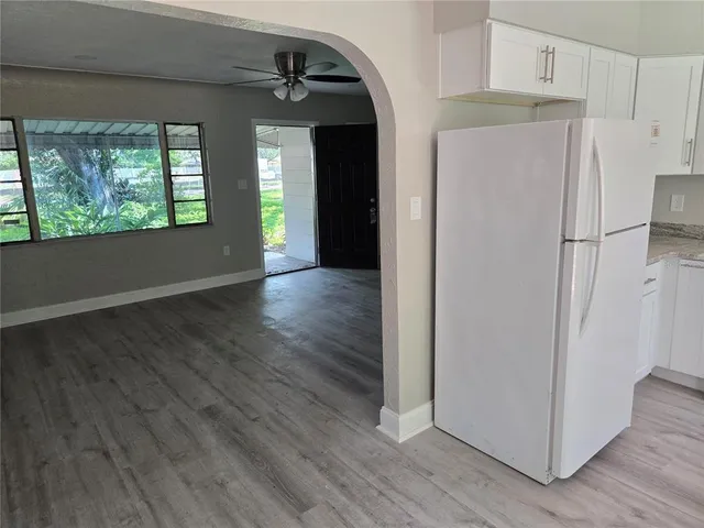 a view of a kitchen with wooden floor and a refrigerator