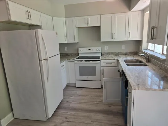 a kitchen with a stove a refrigerator and a sink