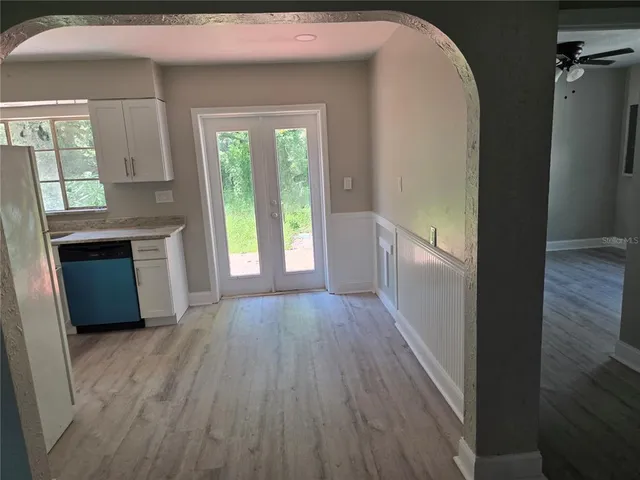 a view of an empty room with a window and wooden floor