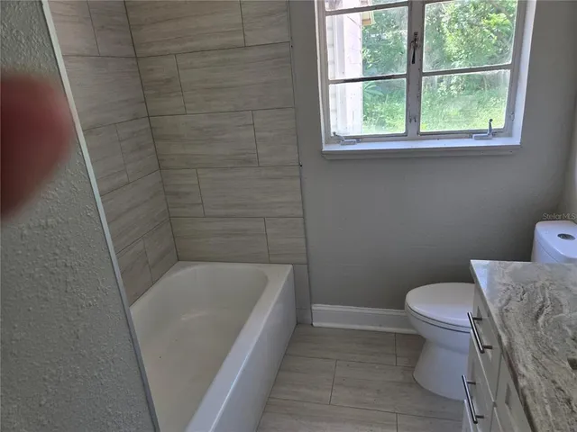 a bathroom with a toilet and bathtub