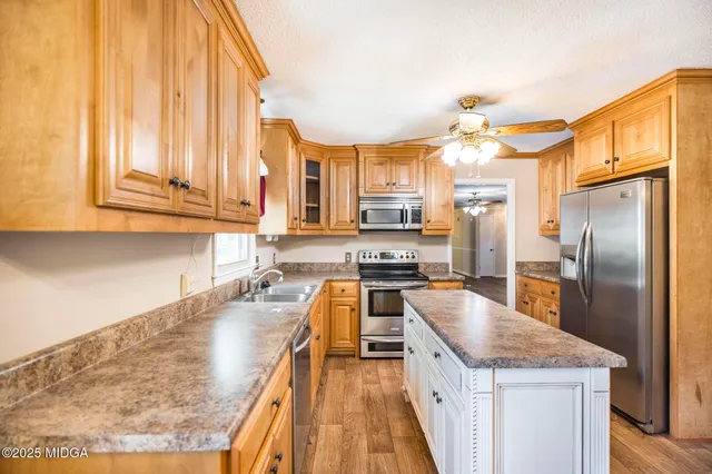 a kitchen with stainless steel appliances granite countertop a sink a stove and refrigerator